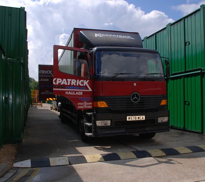 A haulage truck backing up directly to Eversley's storage containers.